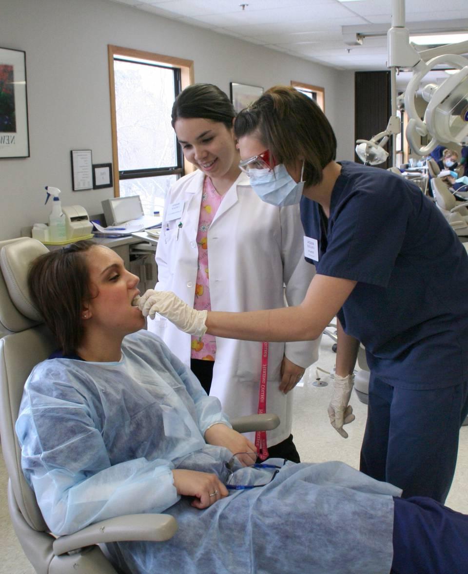 Herzing dental hygiene students learning oral care under supervision of instructor