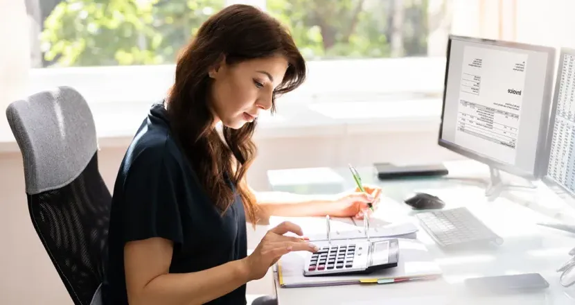 Accountant Seated at Desk Calculating Balances